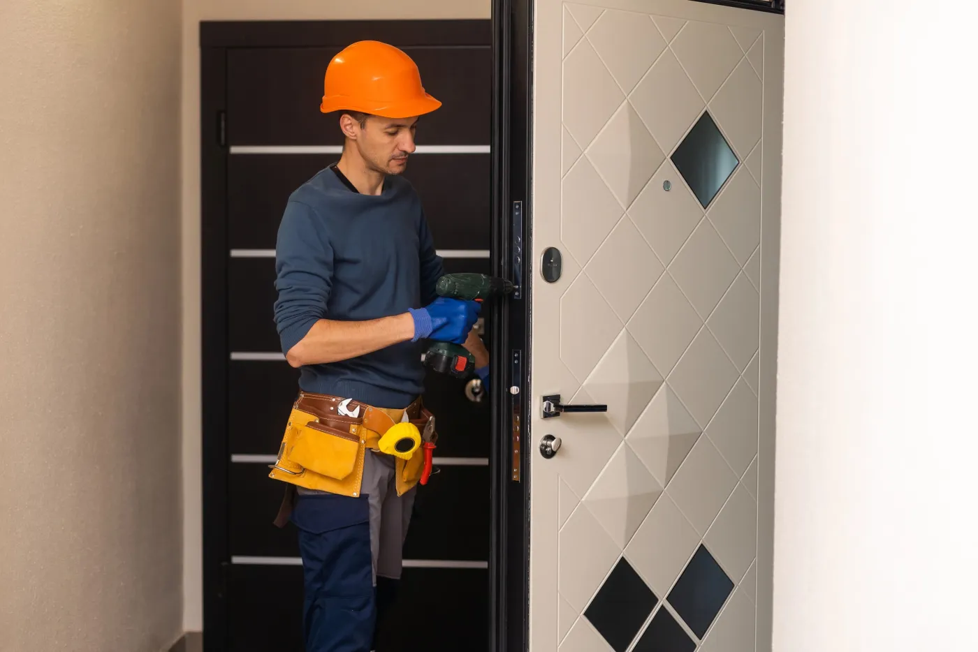 Serrurier installant une serrure sur une porte d'immeuble dans le quartier Arts-et-Métiers, Paris 3e (75003)
